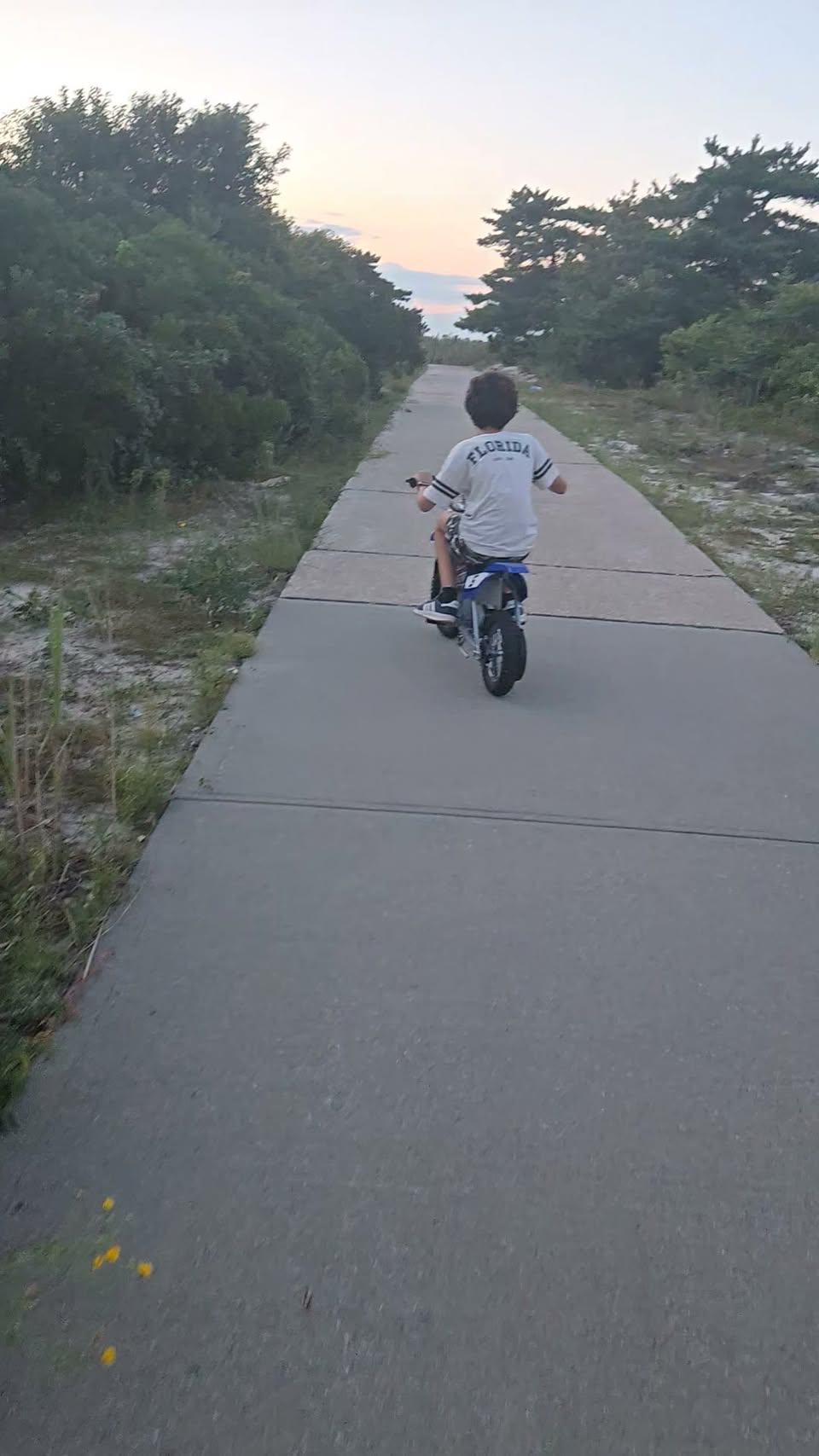A rider on a paved beach path at sunset in a frame from Leo's public Tobay Beach reel